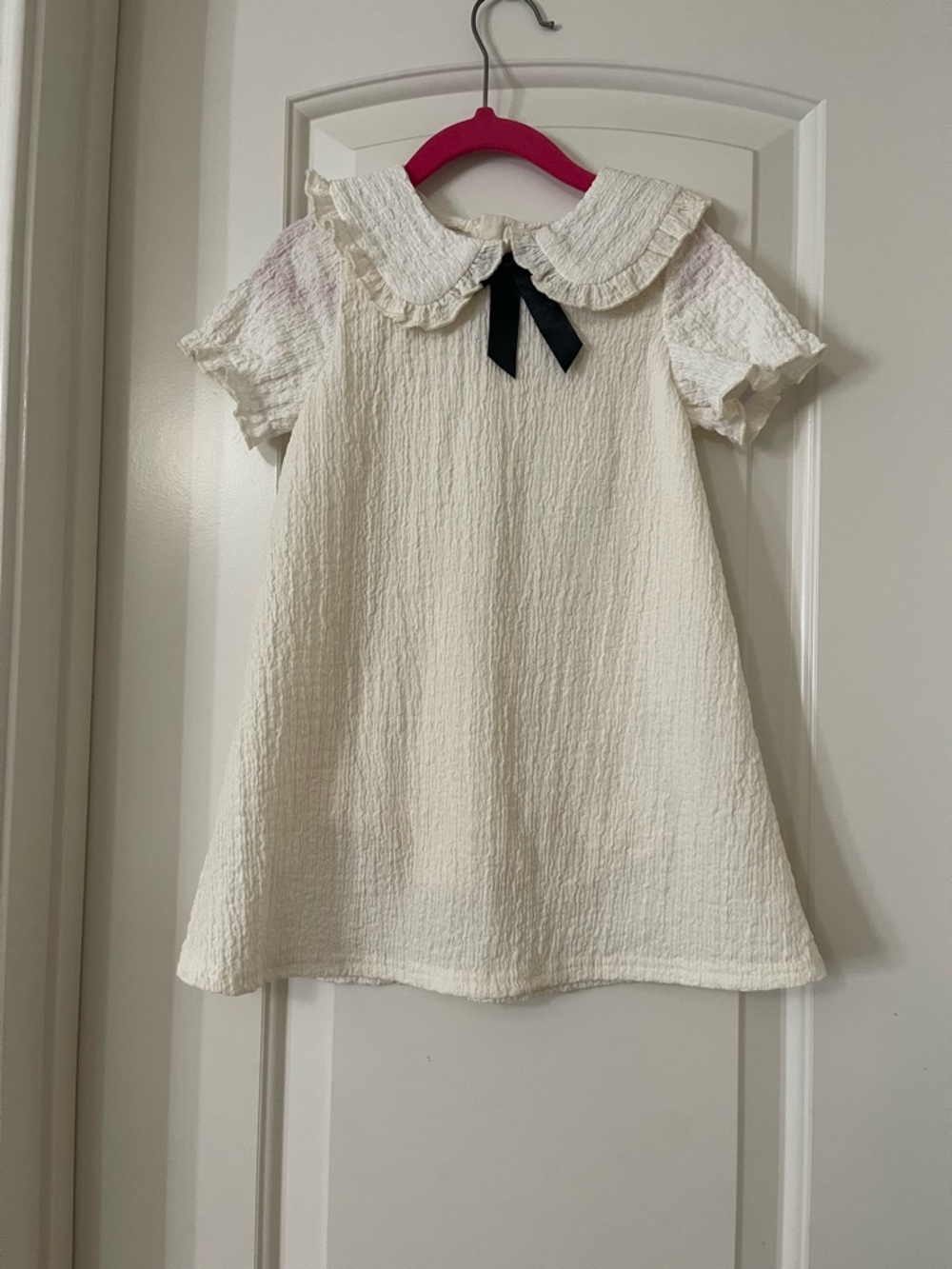 🎀 Girls' Cream Textured Peter Pan Dress with Black Bow